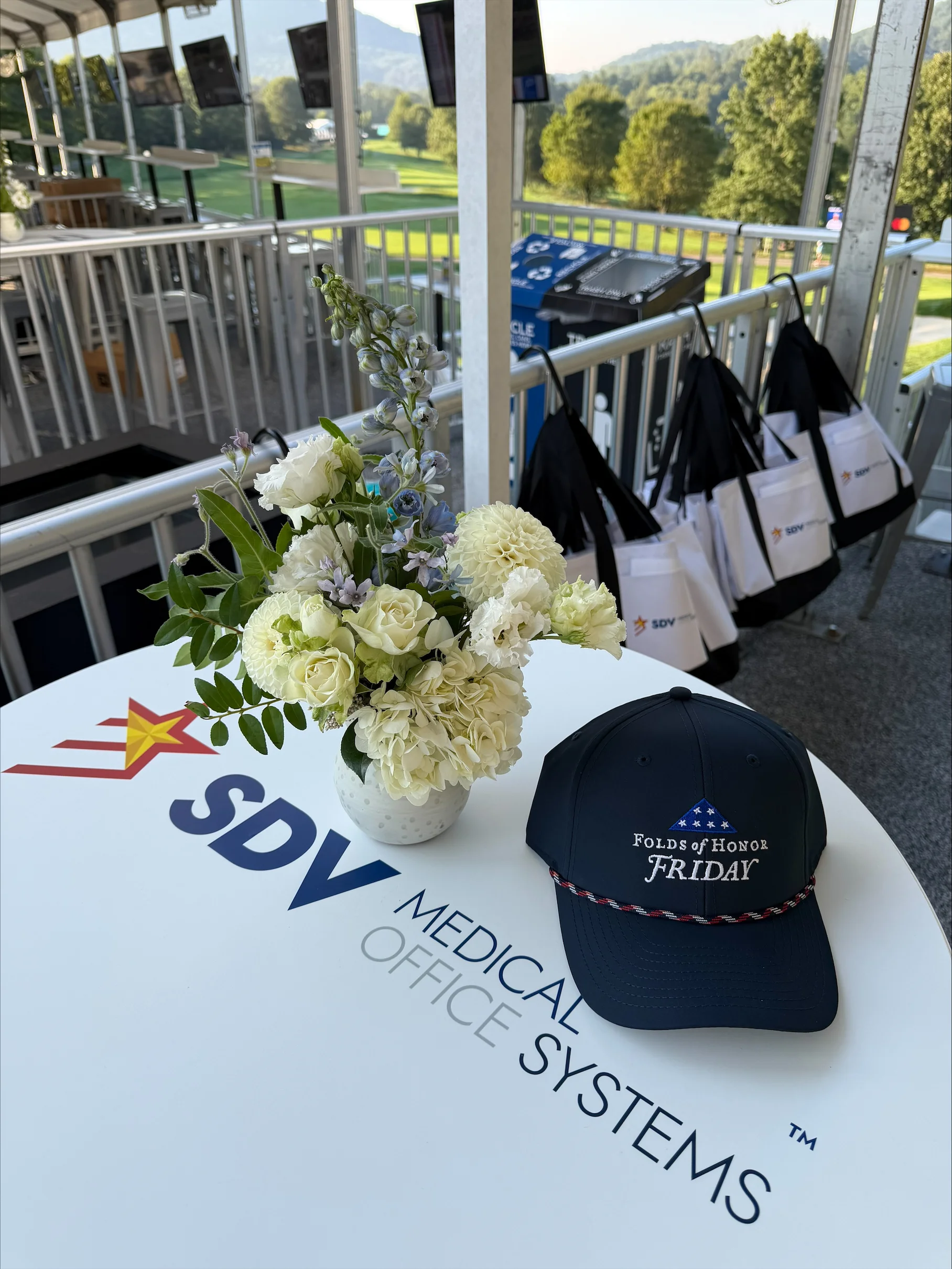 SDV Hospitality at the Biltmore Championship Asheville SDV Medical and Office Systems hospitality area overlooking the golf course at the Biltmore Championship Asheville, featuring an SDV-branded table and Folds of Honor Friday giveaway display.